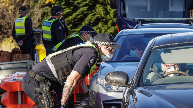 Victoria Police members stop motorists leaving metropolitan Melbourne on Sunday.