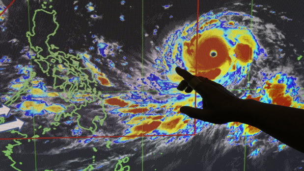 Filipino forecaster Meno Mendoza illustrates the path of typhoon Mangkhut.