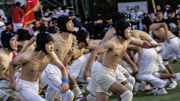 Two packs charge past one another in game of botaoshi, in which students try to topple an opposing’s team pole while protecting their own, at the Kaisei Gakuen school’s annual festival in Tokyo.