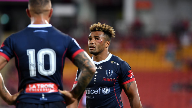 Ex-Reds stars Will Genia (right), who played with an infected cheek, and Quade Cooper conferring during the Rebels' win over Queensland at Suncorp on Saturday.