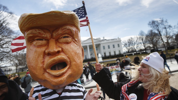 A person dressed up as President Donald Trump in a prison uniform in front of the White House.