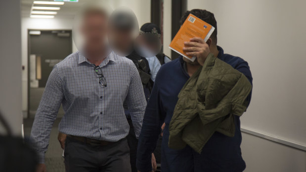Maythem Radhi is taken into custody at Brisbane Airport.