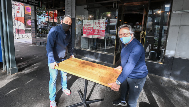 Tiamo's Fab Succi (left) and manager Giulio Damante setting up a table outside their restaurant for the first time in months.
