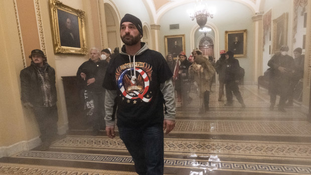 Smoke fills the walkway outside the Senate Chamber as rioters storm the Capitol. 