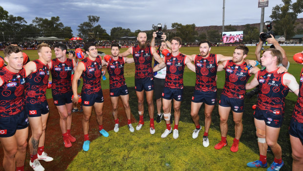 Hope spring eternal: Demons gather to celebrate an emphatic win over the Crows at TIO Traeger Park in Alice Springs.