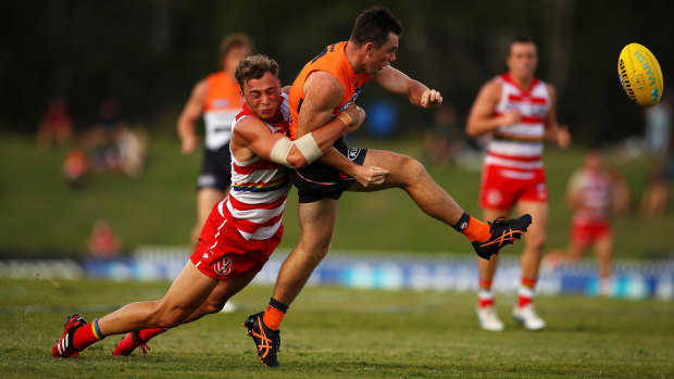 Chad Warner lays a tackle on GWS' Brent Daniel during a Marsh Community Series match earlier this year.