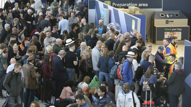 People wait near the departures gate at Gatwick airport after all flights were cancelled.