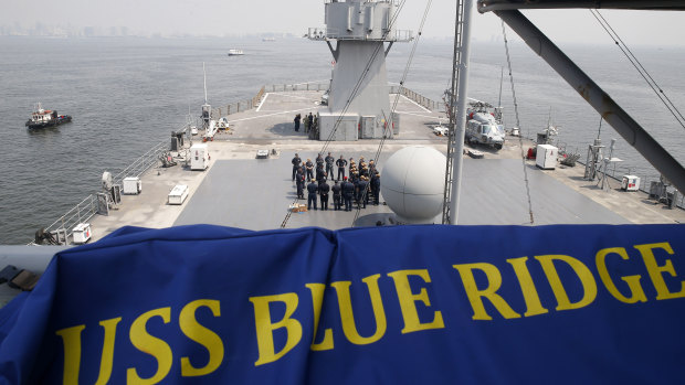 US Navy sailors gather on the deck of the USS Blue Ridge as it anchors off Manila Bay in the Philippines.