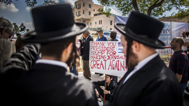 Ultra orthodox Jews stand by supporters of Donald Trump outside the new American embassy in Jerusalem on Monday.