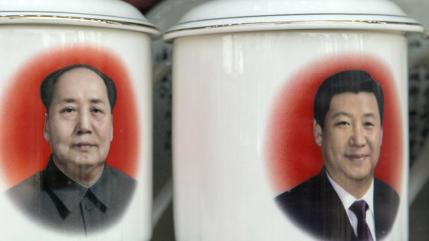 Porcelain cups featuring portraits of former Chinese leader Mao Zedong and current President Xi Jinping in a store window in Beijing.