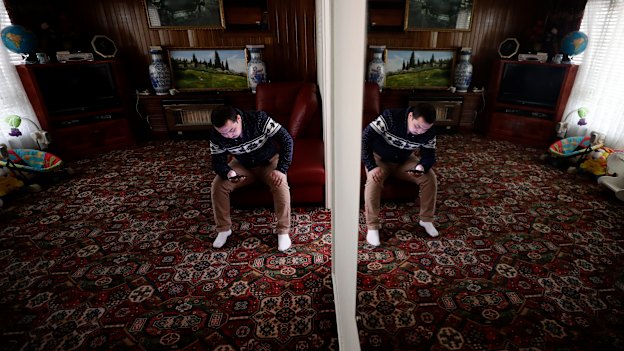 Almas Nizamdin checks the news on the Uighur community on his phone.