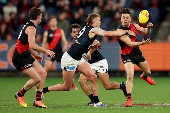 Isaac Kako handballs under real heat from Blues skipper Patrick Cripps.