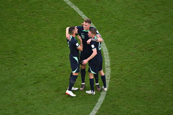 Milos Degenek, Harry Souttar and Kye Rowles embrace after Australia’s win over Tunisia.