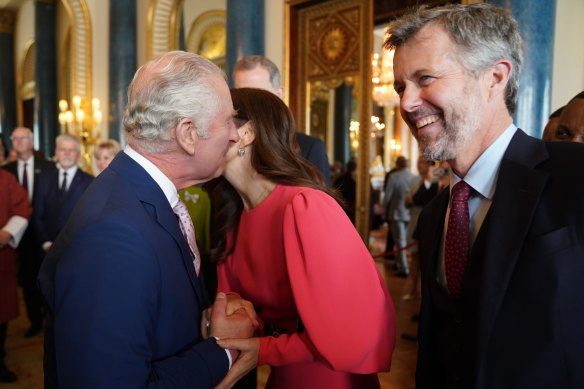 King Charles III (L) greets Mary, Crown Princess of Denmark and Crown Prince Frederik of Denmark during a reception at Buckingham Palace.