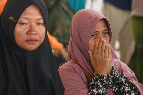 A woman weeps at Ketapang Port in East Java after her relative boarded a ferry that sank overnight on its way to  Bali.