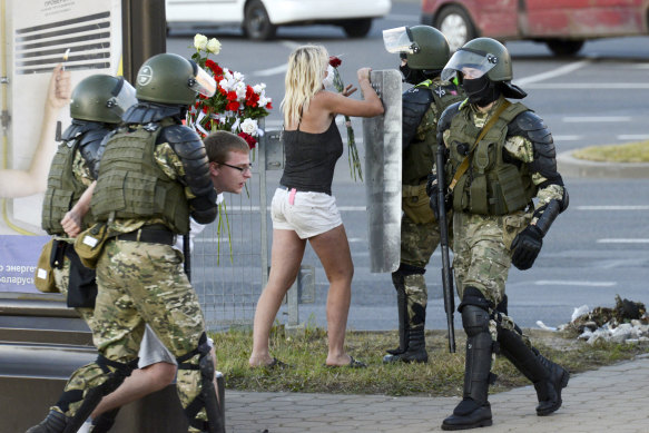 People clash with police officer while protesting against the election results in Minsk on Tuesday.