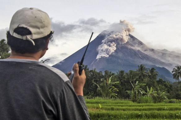 A volunteer monitors Mount Merapi during an eruption.