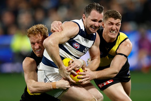 Patrick Dangerfield of the Cats is tackled by Nick Vlastuin (left) and Ben Miller of the Tigers.
