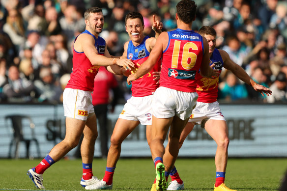 Hugh McCluggage of the Lions celebrates a goal with teammates.