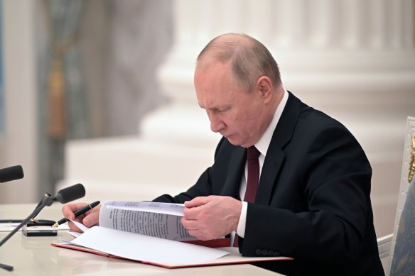Russian President Vladimir Putin signs a document recognizing the independence of separatist regions in eastern Ukraine in the Kremlin in Moscow, Russia, Monday, Feb. 21, 2022.