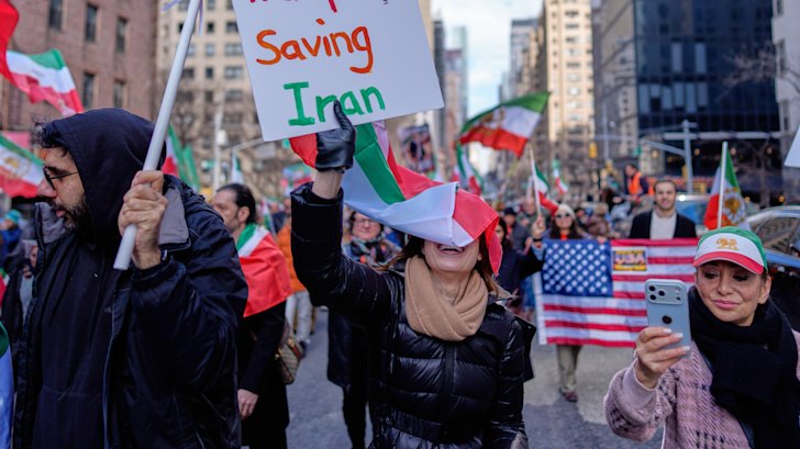 People hold signs in New York thanking President Donald Trump. 