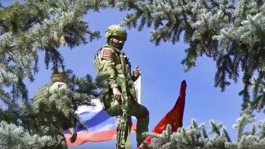 Russian soldiers set a national flag and a replica of the Victory banner after capturing the village of Bilohorivka in Luhansk, eastern Ukraine.