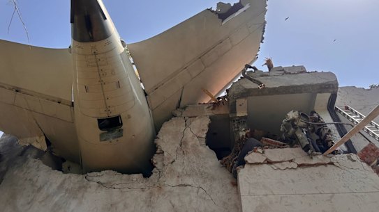The tail of the Air India plane is seen sticking out of a building in Ahmedabad.