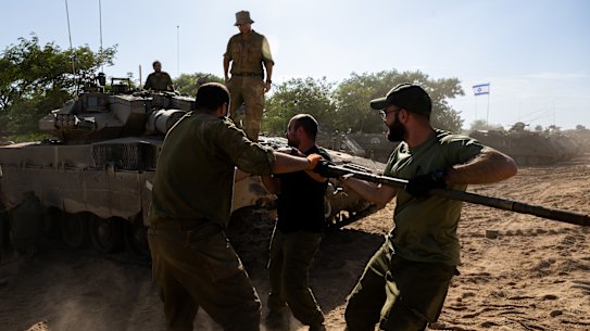 Israeli soldiers clean the barrel of a tank in southern Israel.
