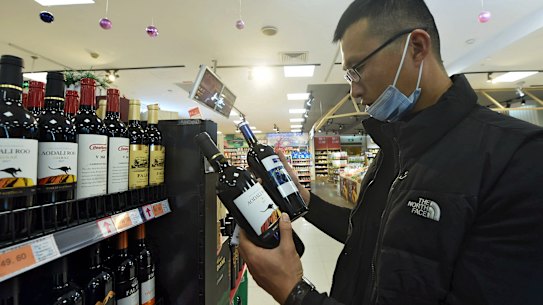 A man compares two bottles of Australian wine at a supermarket in Hangzhou in east China’s Zhejiang province.