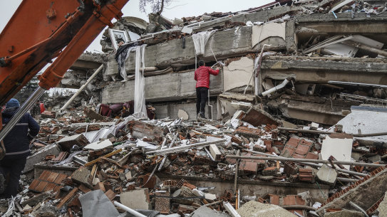 A man searches for people in the rubble of a destroyed building at Gaziantep, Turkey.