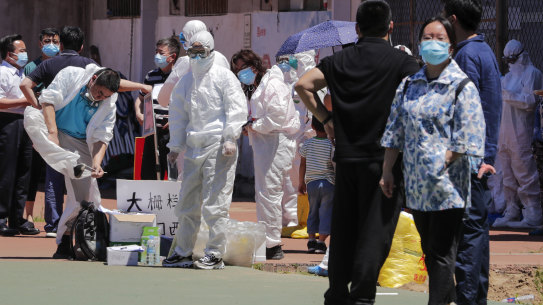 Workers put on protective suits near the Xinfadi wholesale market in Beijing.