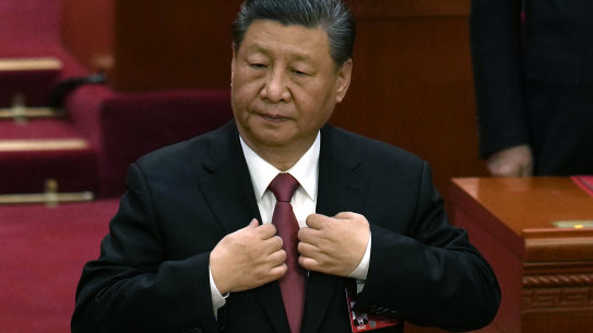 Chinese President Xi Jinping adjusts his jacket during the closing session of the National People’s Congress held at the Great Hall of the People in Beijing on Monday.