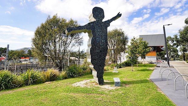 A sculpture at Bayswater train station of a little boy doing an aeroplane stance.