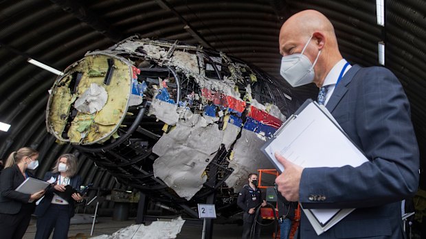 FILE - Presiding judge Hendrik Steenhuis, right, other trial judges and lawyers view the reconstructed wreckage of Malaysia Airlines Flight MH17, at the Gilze-Rijen military airbase, southern Netherlands, on May 26, 2021. (AP Photo/Peter Dejong, Pool, File)