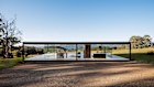 The glass house is wrapped in full-length glass with a living zone and bedroom, which can be curtained off internally.
