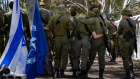 Israeli soldiers embrace at a memorial for the October 7 massacre in Re’im, Israel.