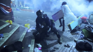 A policeman detains a protester outside of Hong Kong Polytechnic University as police storm the campus  on November 18.