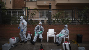 Ffirefighters wearing protective suits wait outside a nursing home before disinfecting it in efforts to prevent the spread of the new coronavirus in Barcelona, Spain, Monday, March 30, 2020. Governments in Europe's hardest-hit countries have yet to systematically test the residents of nursing homes or those who receive in-home care. In Spain, Italy and France, which together account for a third of the world's confirmed coronavirus cases, no one knows for sure how many people have become sick and died of coronavirus, especially among the elderly. The new coronavirus causes mild or moderate symptoms for most people, but for some, especially older adults and people with existing health problems, it can cause more severe illness or death. (AP Photo/Felipe Dana)