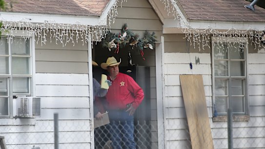 San Jacinto County Sheriff Greg Capers talks to investigators at the scene where five people were shot and killed the night before.