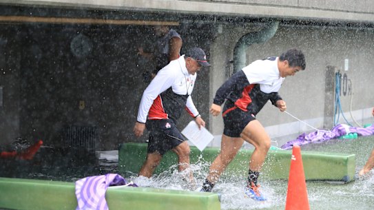Japan players soaked before their captain's run in Tokyo.