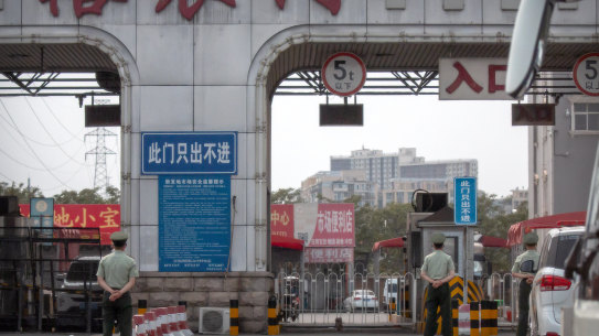 Chinese paramilitary police stand guard at barricaded entrances to the Xinfadi wholesale food market district in Beijing on Saturday.