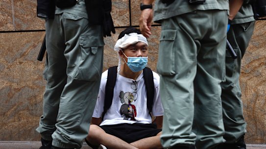 Riot police guard a protester as a second reading of a controversial national anthem law takes place in Hong Kong on Wednesday.