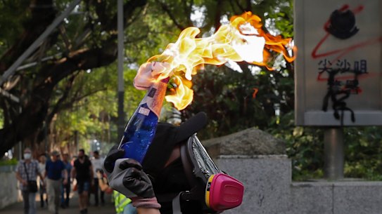 A protester prepares to throw a molotov cocktail at the Tsim She Tsui police station during Sunday's protests.