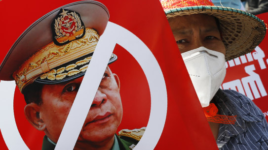 A protester holds a placard with the face of Myanmar’s commander in chief, Senior General Min Aung Hlaing during a rally in Mandalay.