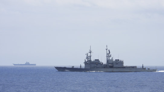 A Taiwanese navy ship Keelung, foreground monitors the Chinese aircraft carrier Shandong in the  background near Taiwanese waters.