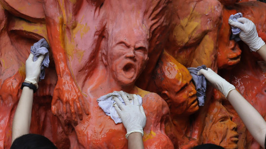 University students clean the “Pillar of Shame” statue, a memorial for those killed in the 1989 Tiananmen crackdown, at the University of Hong Kong in 2019.
