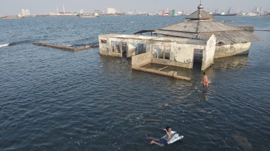 Children swim next to an abandoned mosque in Jakarta.