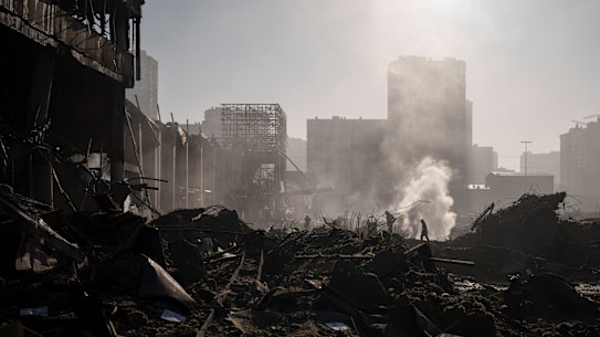 Firefighters extinguish a fire near a shopping centre after shelling, in Kyiv, Ukraine.