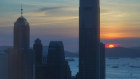 The skyline of the business district is silhouetted at sunset in Hong Kong.  