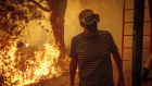 A man watches as flames from the Palisades Fire close in on his property in the Pacific Palisades neighbourhood of Los Angeles.